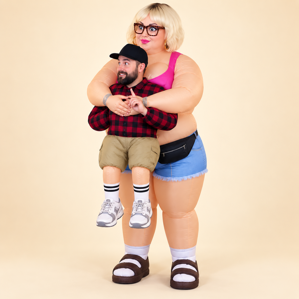 Carry Me costume concept: a blonde inflatable woman with glasses, a pink top and denim shorts stands behind a male wearer. Her arms wrap around his upper torso and clasp in front, while fake khaki-short legs dangle in front of her, making it look like she is carrying him.